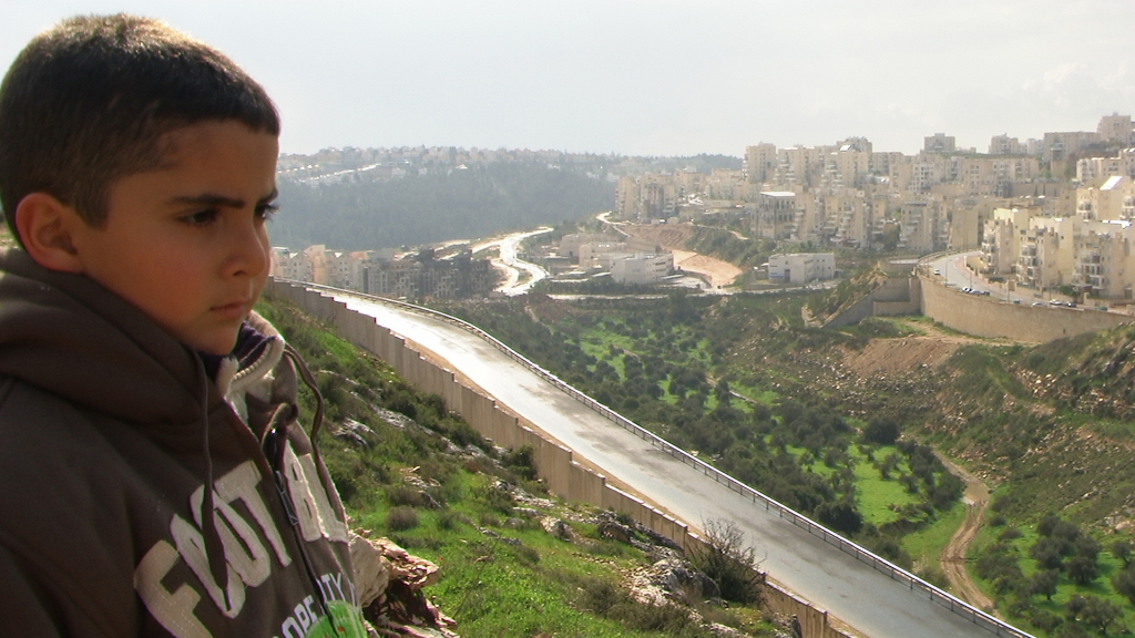 Emad's son Gibreel looks over at the Israeli settlements. 