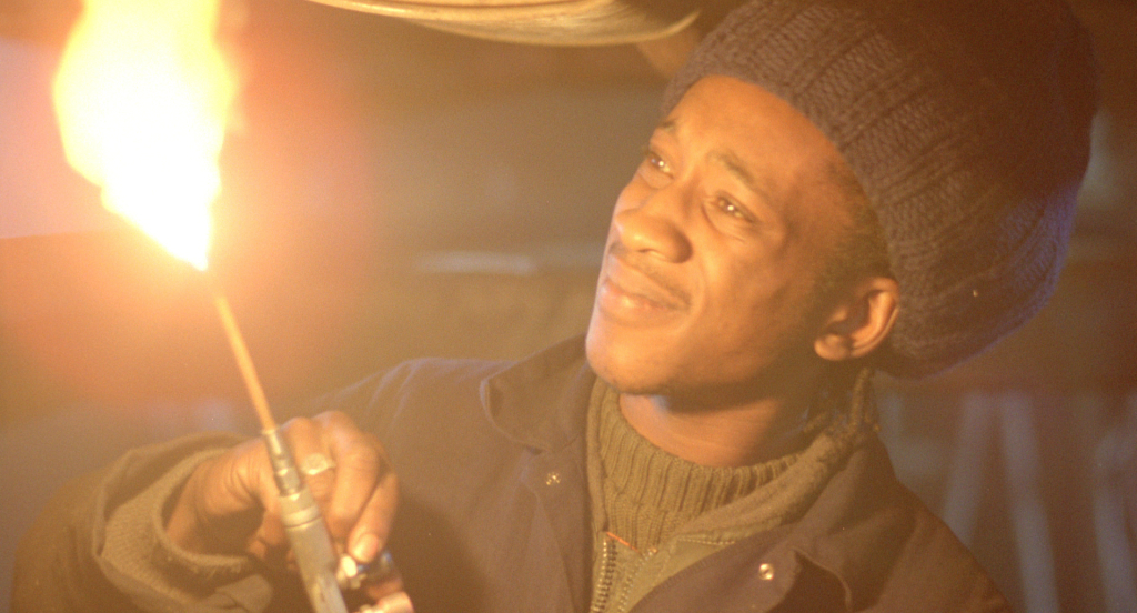 By day, Blue (Brinsley Forde) works as a mechanic in Franco Rosso's BABYLON.