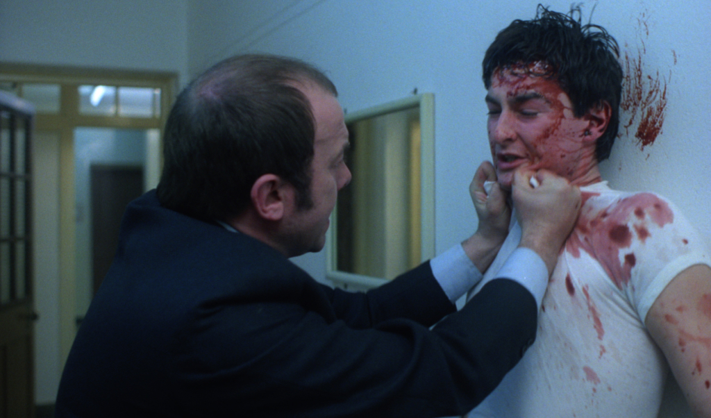 John Judd as Sands, one of the screws, and a bloodied John Blundell as Pongo in Alan Clarke's SCUM