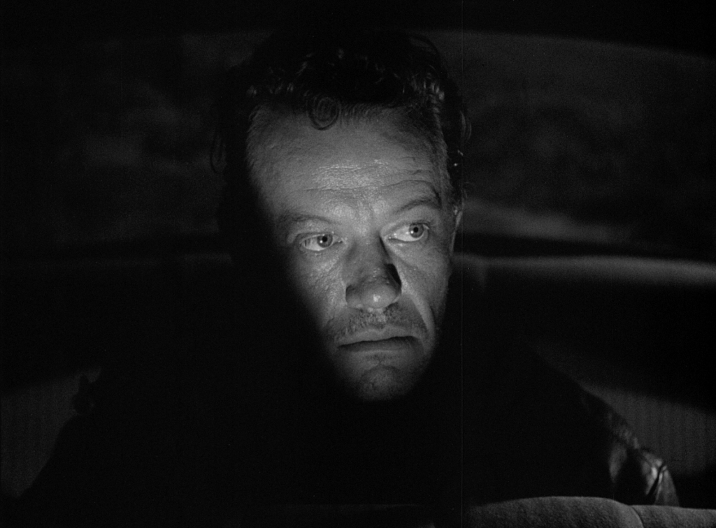 William Talman's Emmett Myers emerges from the shadows in Ida Lupino's THE HITCH-HIKER.
